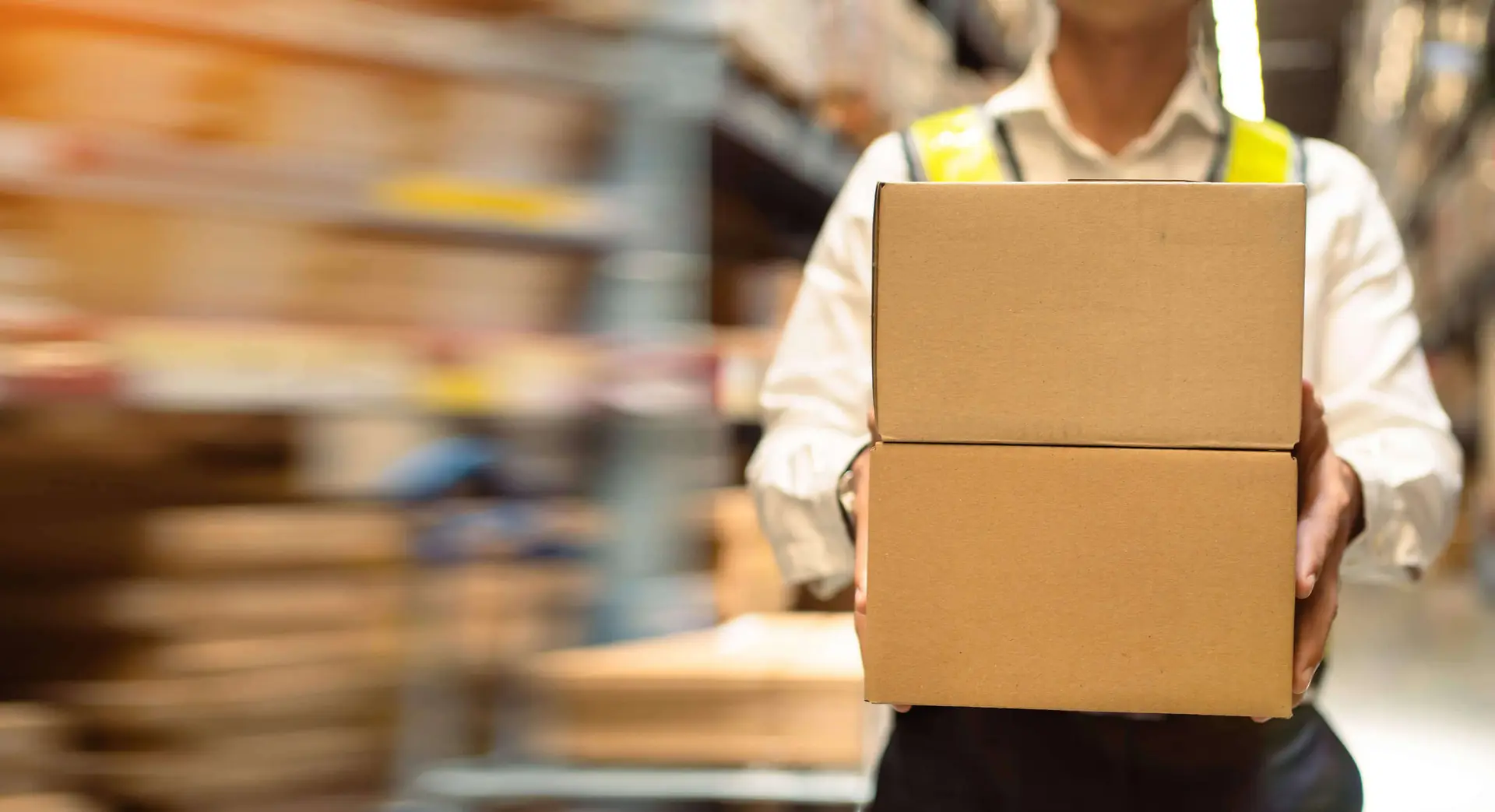 Worker holding a freight box while carrier paperwork is prepared